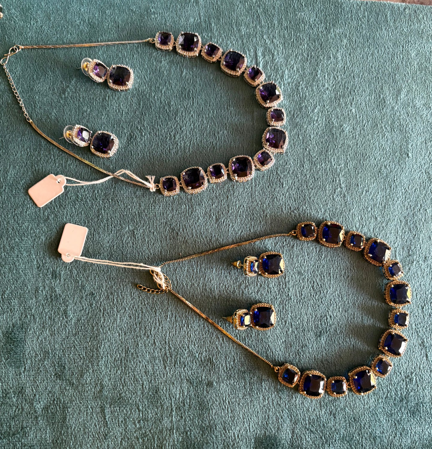Necklaces one with silver purple stones and golden with blue stones